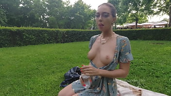 Woman relaxing in park. Flashing beautiful tits